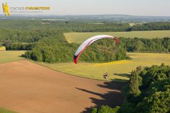Paramoteur en vol au dessus des champs de l'yonne, en région Bourgogne-Franche-Conté,France