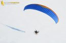 Vue aérienne paysage blanc neige survolé par un parapente à moteur