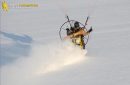 Gros plan de paramoteur planant au-dessus du sol et laissant une trace dans la neige