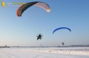 Paramoteur volant en hiver dans les champs enneigés de la région parisienne